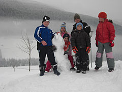 Kinder mit Schneefigur